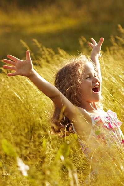 A child happily smiling in a field after seeing a child therapist in Illinois at PRESENT Counseling A child happily smiling in a field after seeing a child therapist in Illinois at PRESENT Counseling
