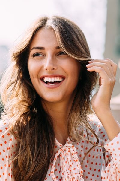 A woman smiling in the sun after emotional abuse recovery therapy online